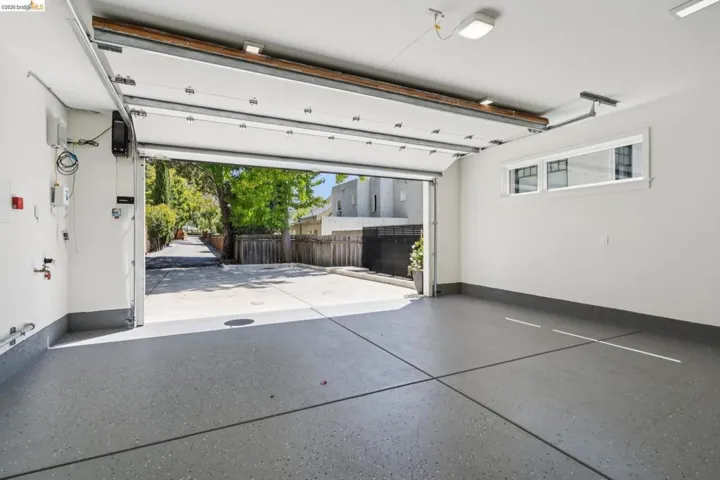 Spacious garage featuring a finished epoxy floor, white walls, and a multi-pane window