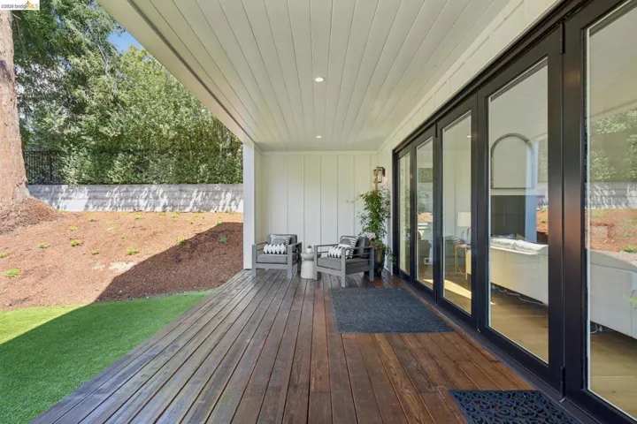 Expansive covered patio featuring wood-finish decking and a white plank ceiling