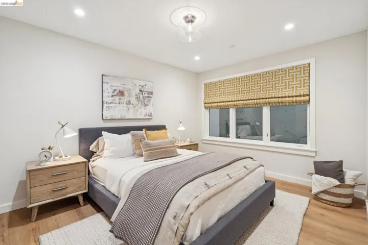 Recessed lighting, wood-finish flooring, and a large window with custom treatments