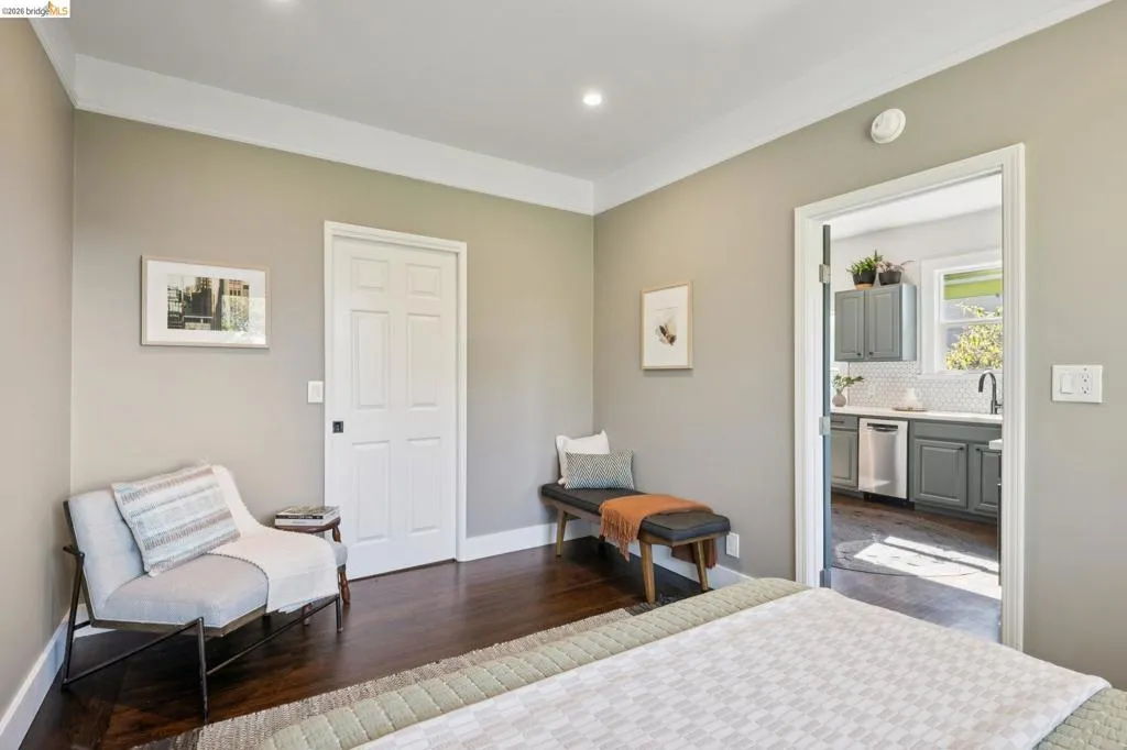 Wood-finish flooring, recessed lighting, crown molding, and a paneled door