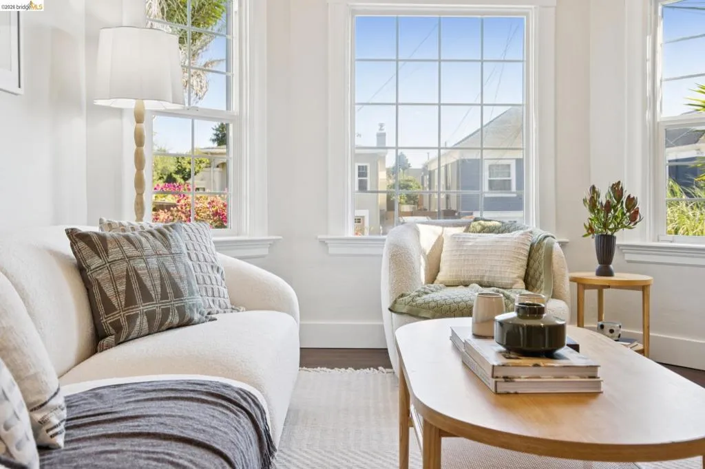 Bright interior with dark wood-finish flooring, white walls, and multiple grid-pattern windows