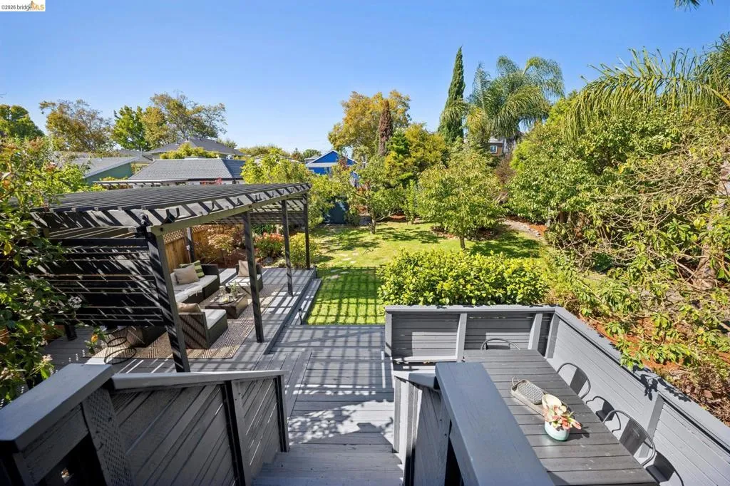 Multi-level deck with a black pergola, composite decking, and integrated dining area