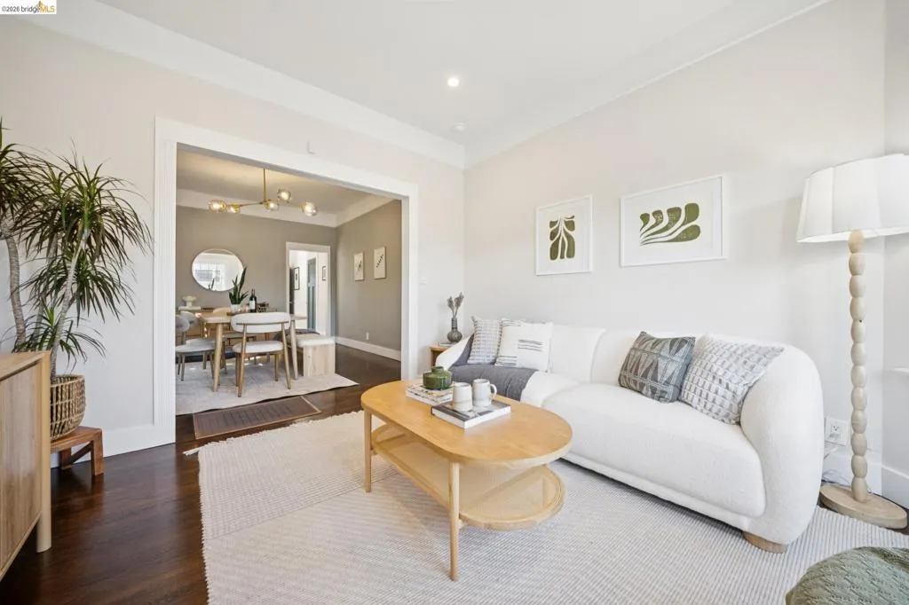 Bright and open living room featuring dark wood-finish flooring, recessed ceiling lighting, and large windows