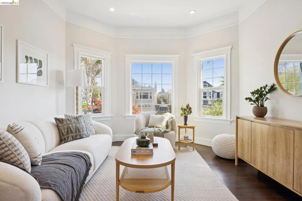 Hardwood flooring, recessed lighting, crown molding, bay windows with grid patterns, and a built-in wood-finish cabinet