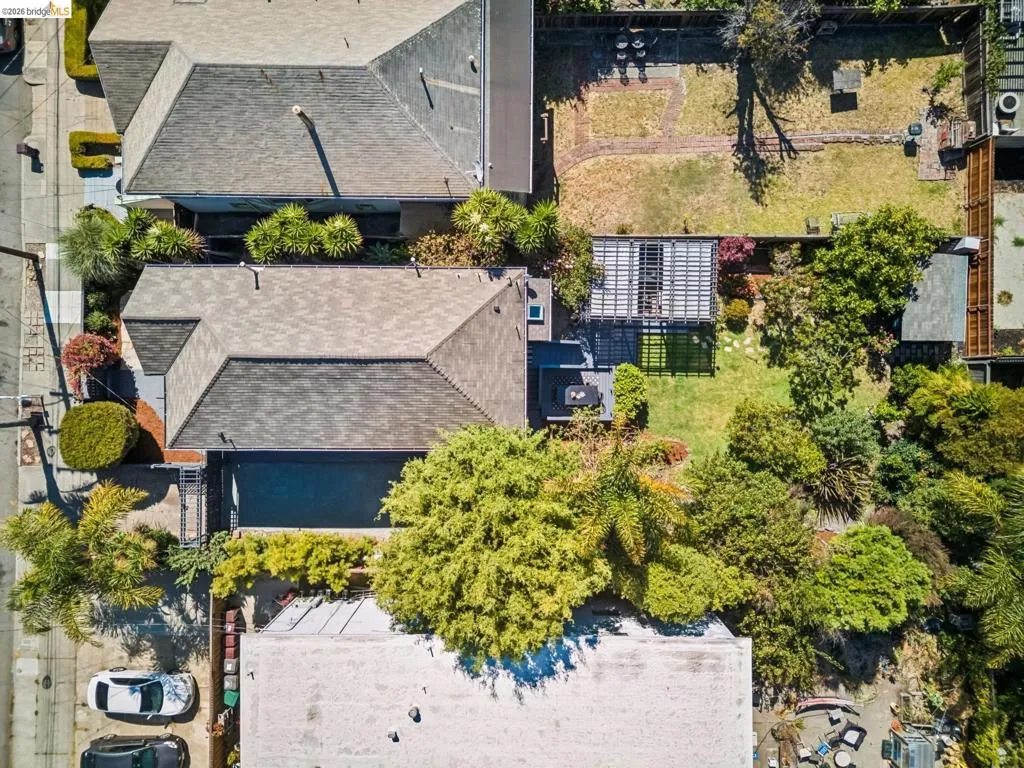 Pitched shingle rooflines, mature landscaping, and an expansive lawn area