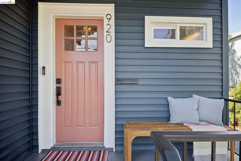 Siding exterior with a paneled entry door featuring upper glass lites and dark hardware