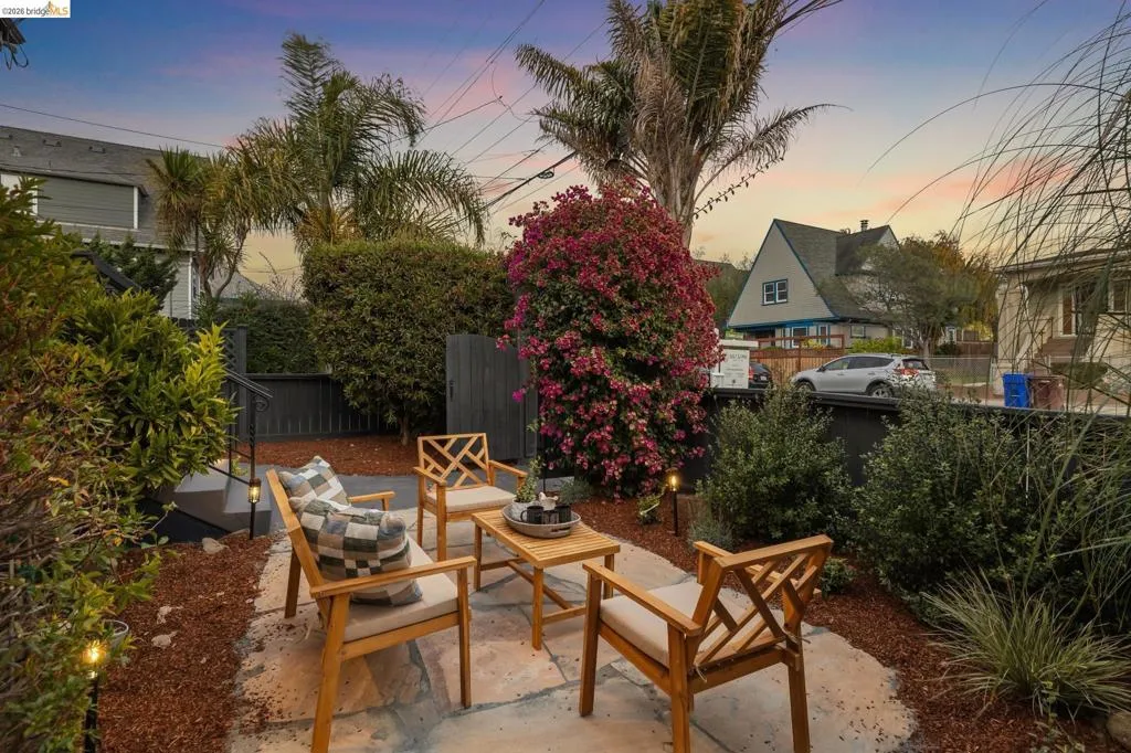 Patio area featuring flagstone paving, integrated landscape lighting, and mature perimeter plantings