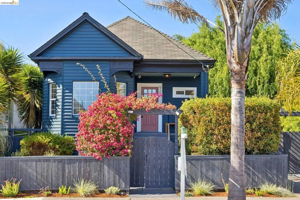 Blue siding exterior with decorative trim, gabled roofline, and a prominent front bay window