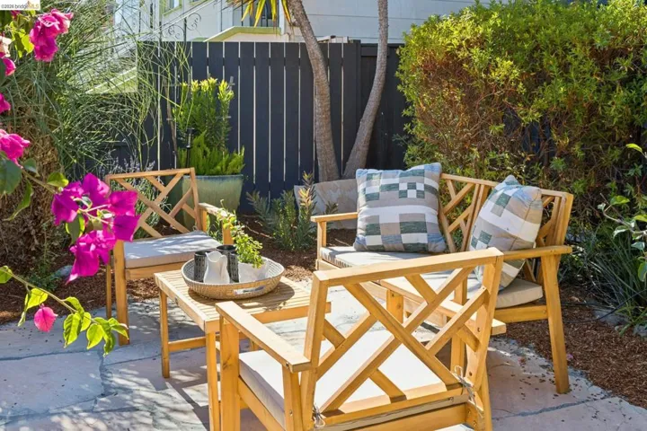 Paved patio area featuring lush landscaping and a dark-toned privacy fence