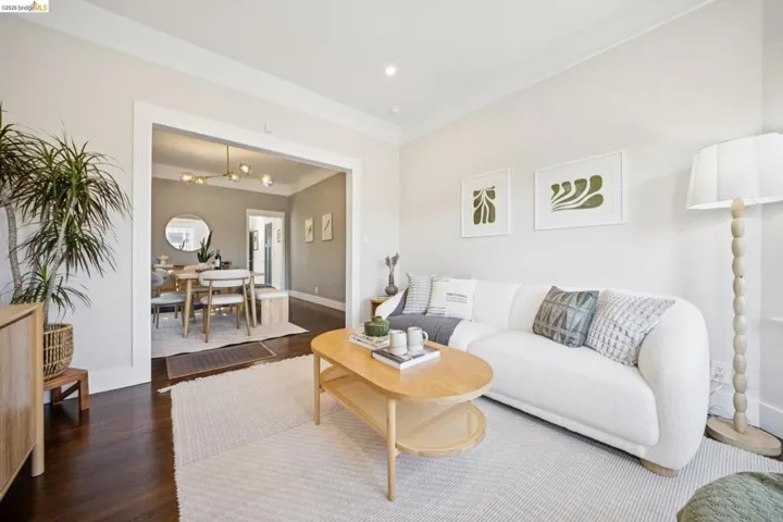 Bright and open living room featuring dark wood-finish flooring, recessed ceiling lighting, and large windows