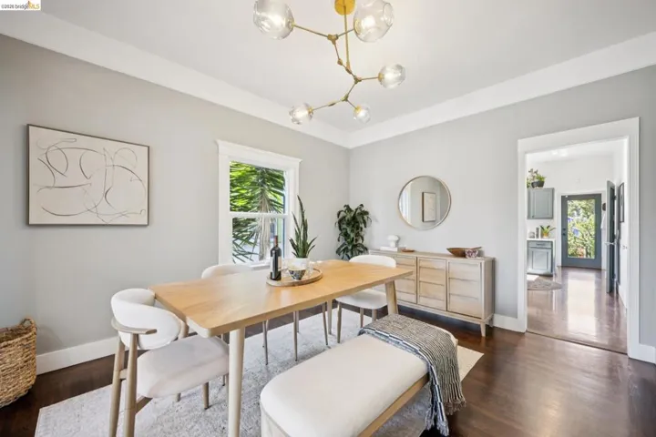 Hardwood-style flooring, white trim, recessed entry, and a contemporary chandelier