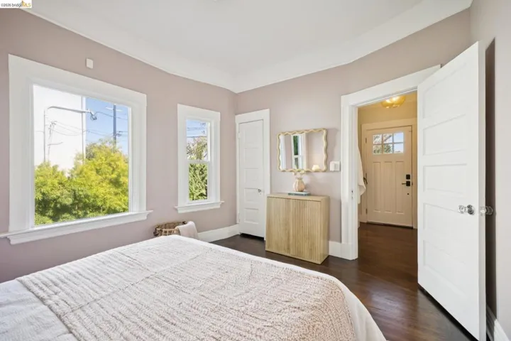 Hardwood flooring, white trim, paneled doors, and a front entry door with glass paneling
