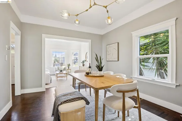 Dining area featuring dark wood-finish flooring, a contemporary chandelier, and bright window