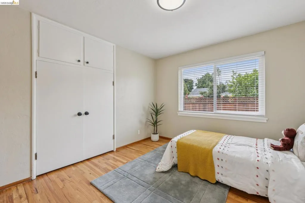 Built-in storage cabinetry, wood-finish flooring, and a flush-mount ceiling light