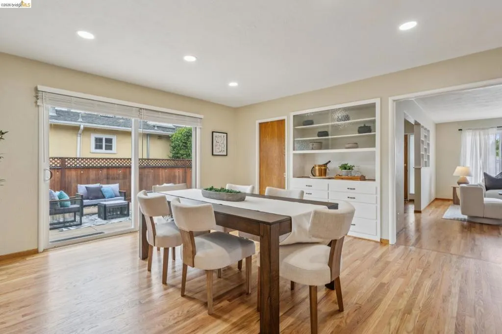 Hardwood flooring, recessed lighting, built-in display cabinetry, and a sliding glass door to an outdoor patio