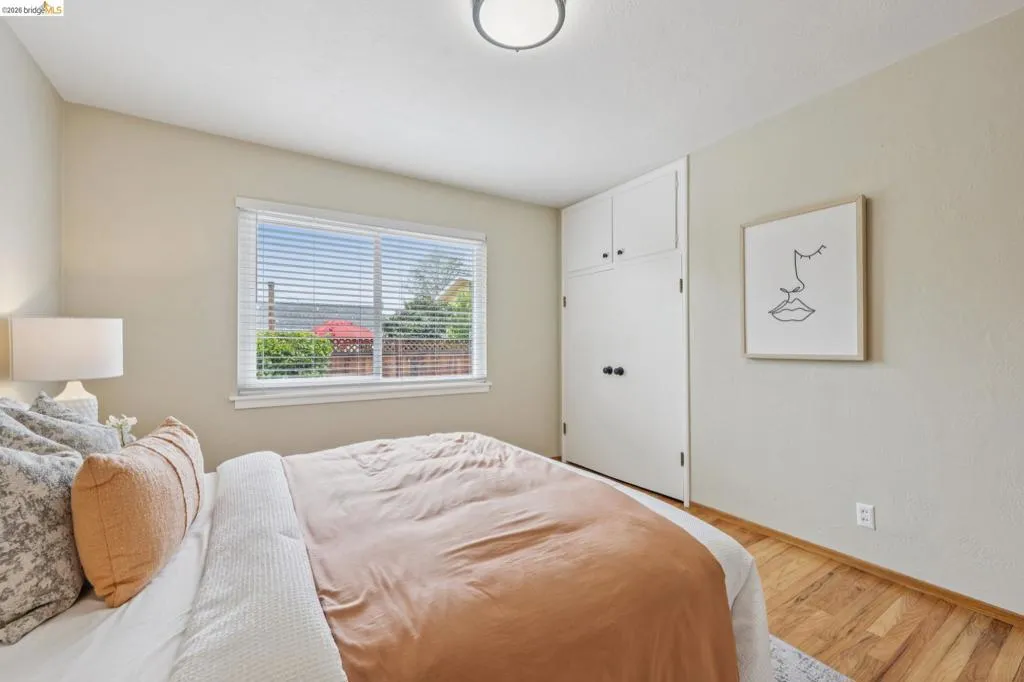 Hardwood flooring, built-in cabinetry, window with blinds, and flush mount lighting