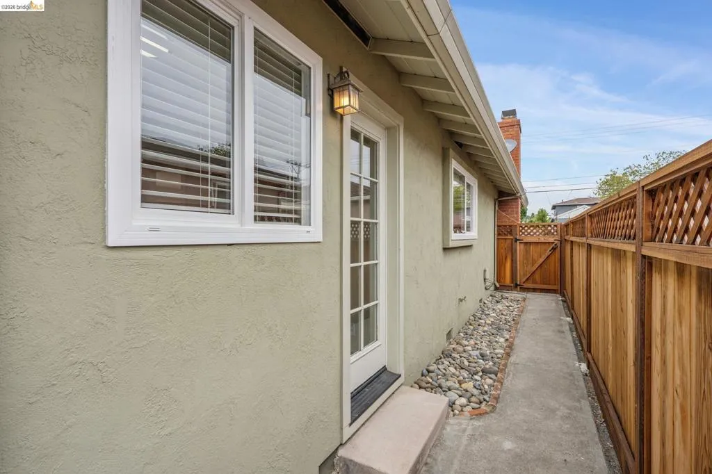 Stucco exterior with white-framed windows and a glass-paneled door