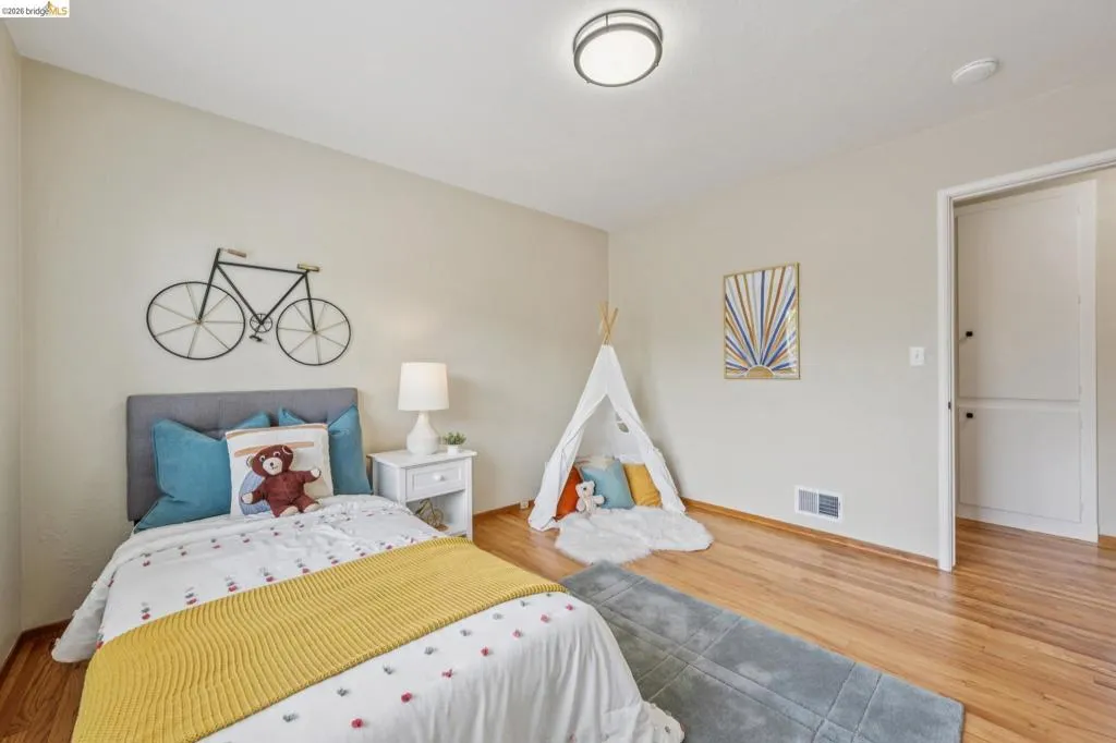 Hardwood flooring, painted walls, white trim, recessed lighting, and a white interior door