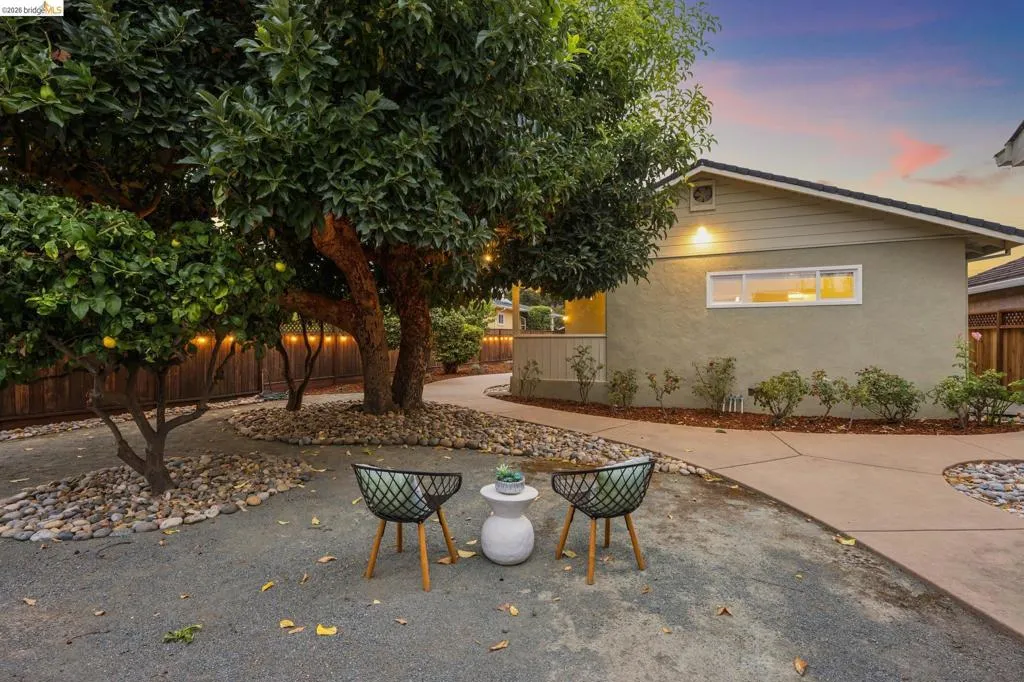 Stucco exterior with a pitched roofline, bordered by a concrete pathway