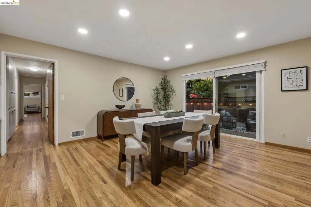Hardwood flooring, recessed lighting, sliding glass door, built-in cabinetry, and neutral wall tones