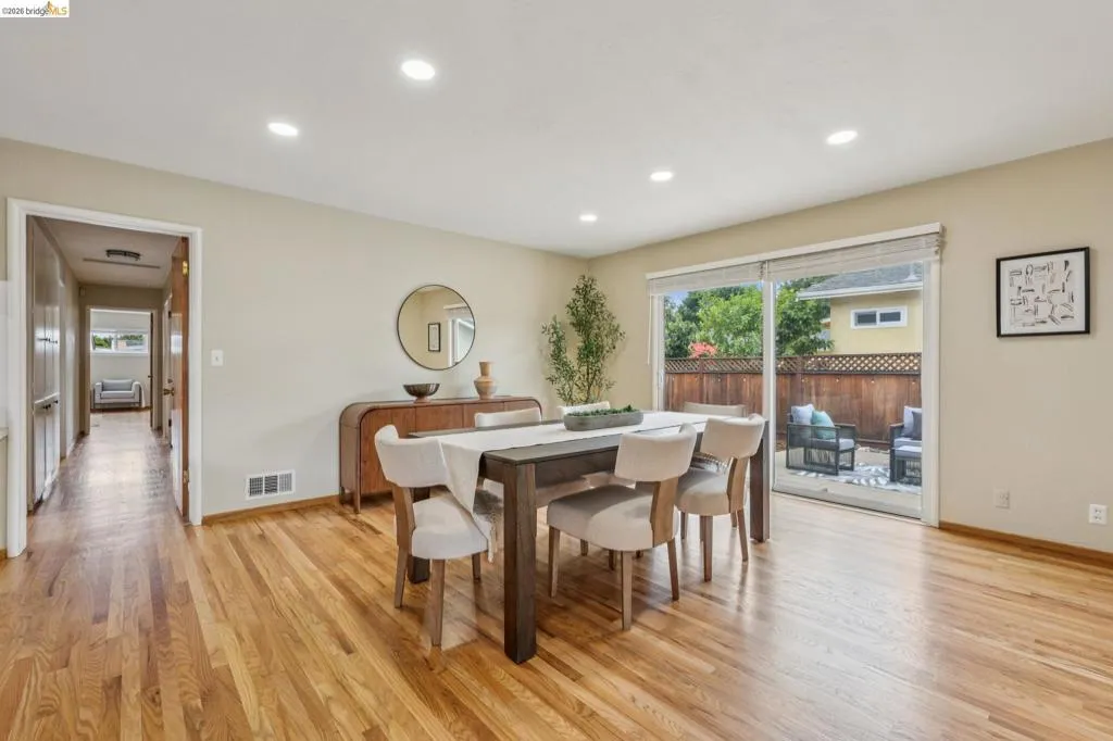 Recessed lighting, wood-finish flooring, sliding glass door, private patio, and wooden fence