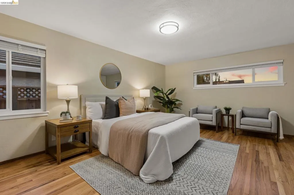 Hardwood flooring, two windows with blinds, recessed lighting, and a neutral color palette
