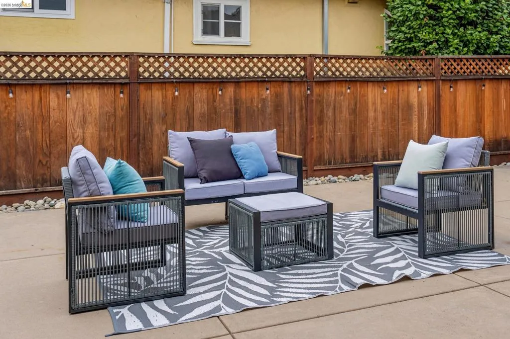 Paved patio space featuring a wood fence with lattice detailing