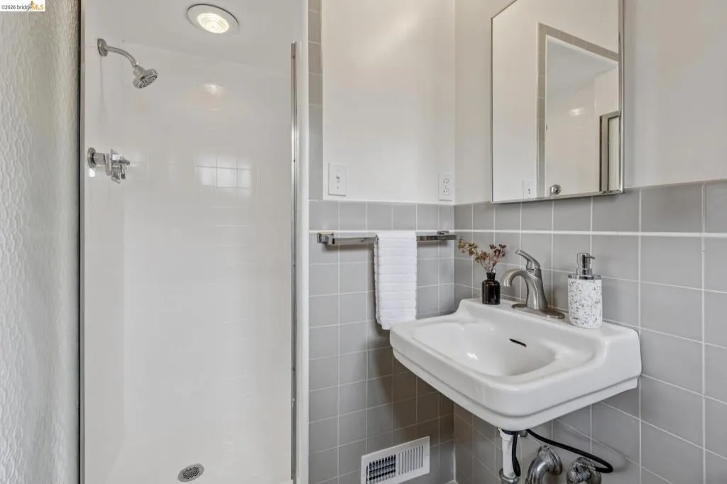 Shower enclosure with built-in overhead lighting and polished chrome fixtures