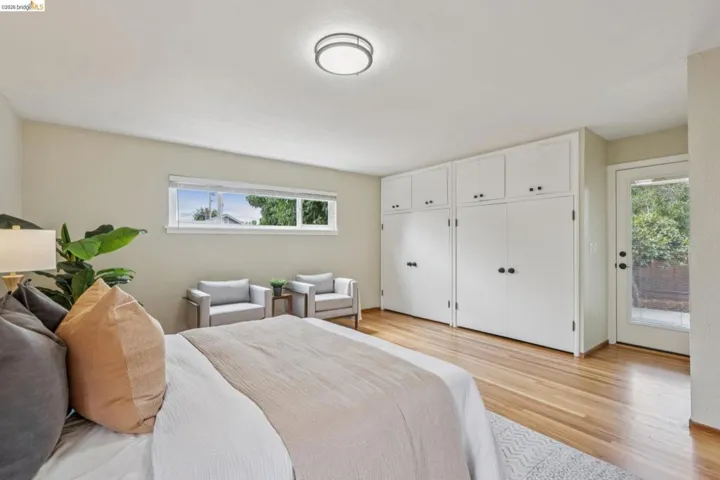 Built-in cabinetry, wood-finish flooring, a full-lite exterior door, and a horizontal window