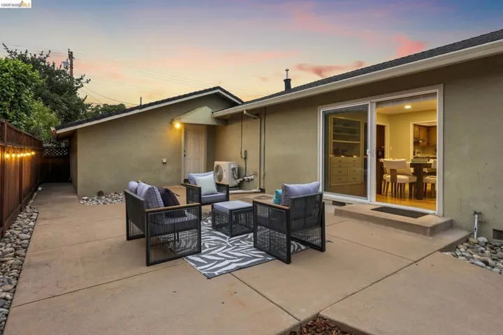 Expansive concrete patio with a full-length wooden privacy fence