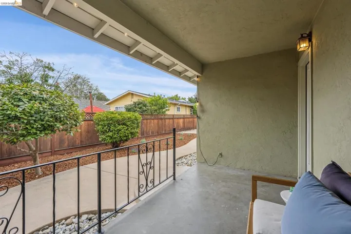 Covered patio featuring concrete flooring and a stucco wall