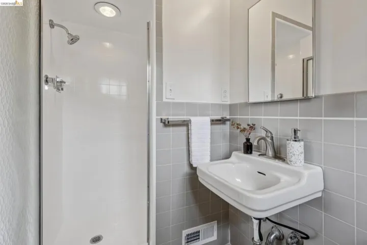 Shower enclosure with built-in overhead lighting and polished chrome fixtures