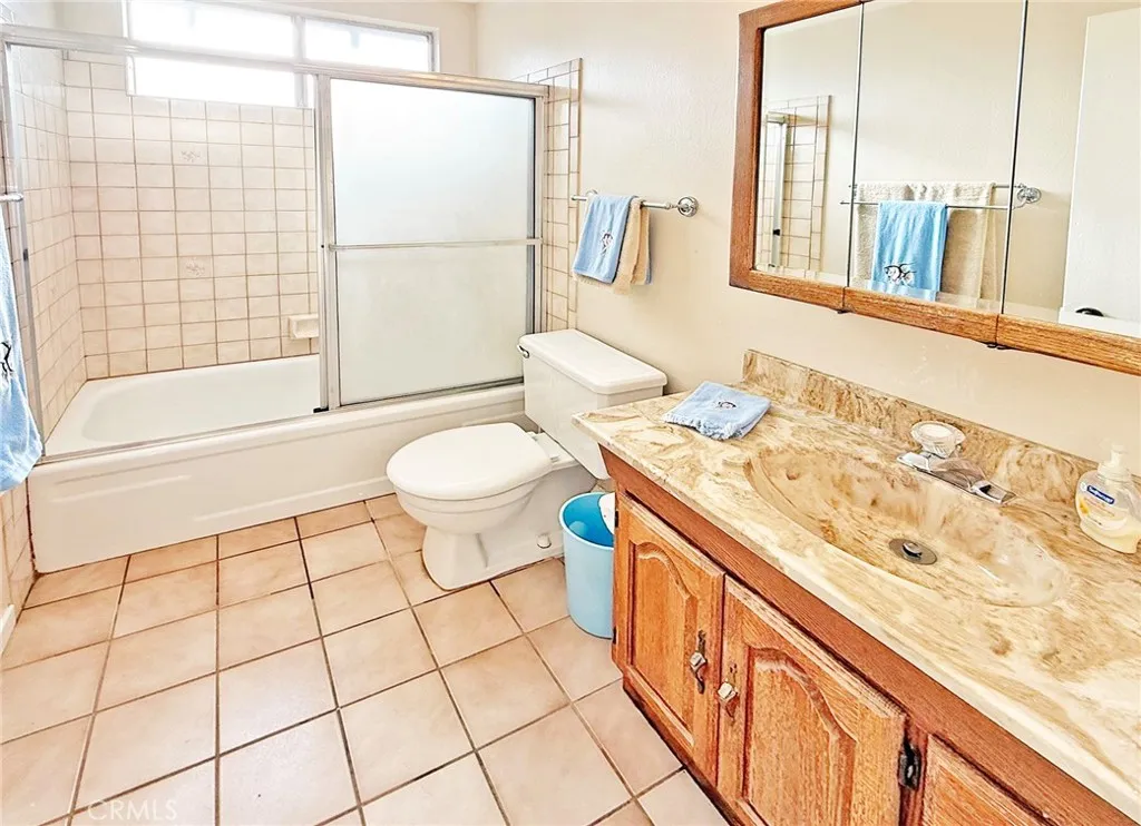 Guest Bath has Tile Floor and a Tub/Shower Combo with Glass Enclosure