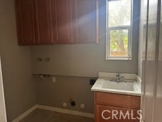 Dedicated laundry room featuring utility sink, cabinetry, and washer/dryer hookups.