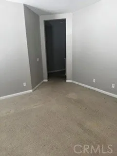 Spacious bedroom with neutral finishes and carpeting.