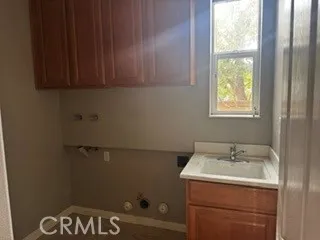 Dedicated laundry room featuring utility sink, cabinetry, and washer/dryer hookups.