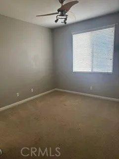 Bedroom featuring ceiling fan, window blinds, and neutral carpeting.