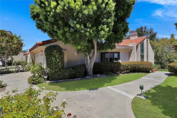 Front and side of home with driveway, garage and high ceilings