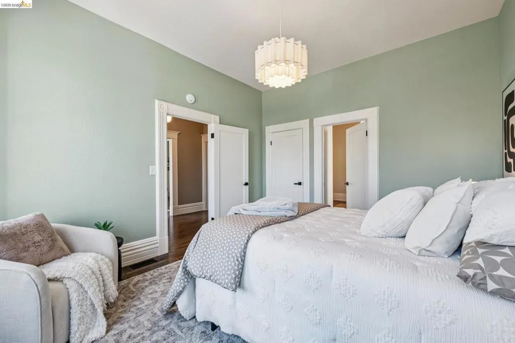 Mint green painted walls with white trim, wood-finish flooring, and a contemporary ceiling light fixture