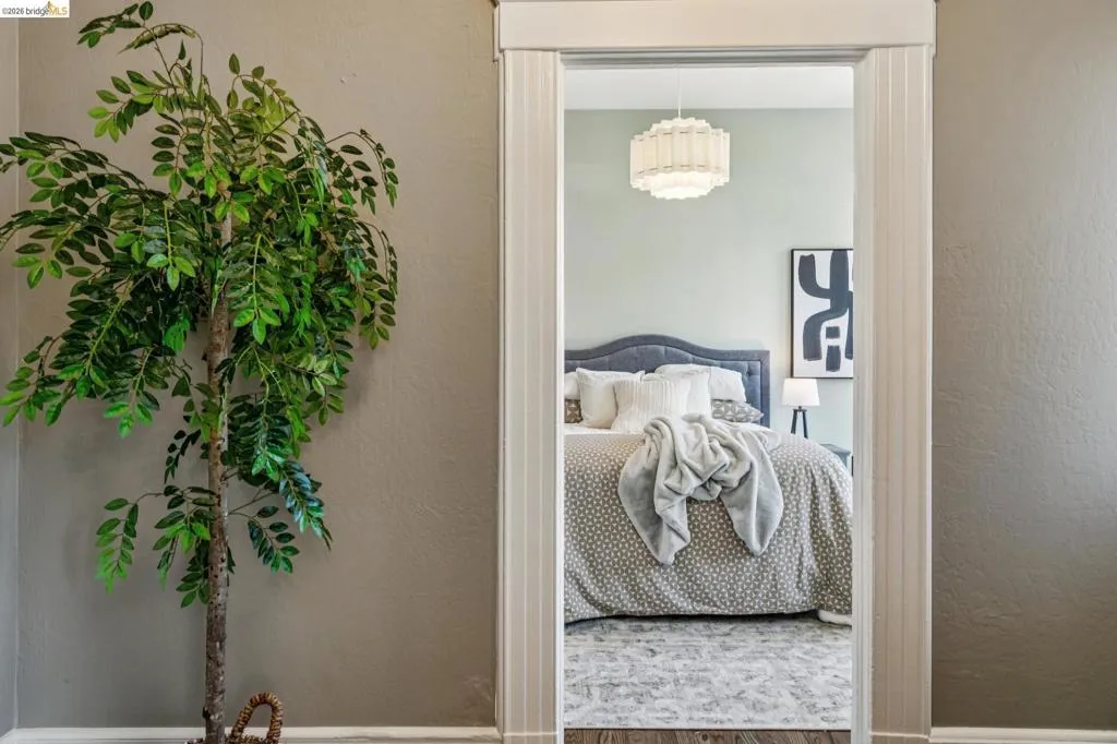 Hardwood-style flooring throughout, detailed door trim, and a decorative ceiling light fixture
