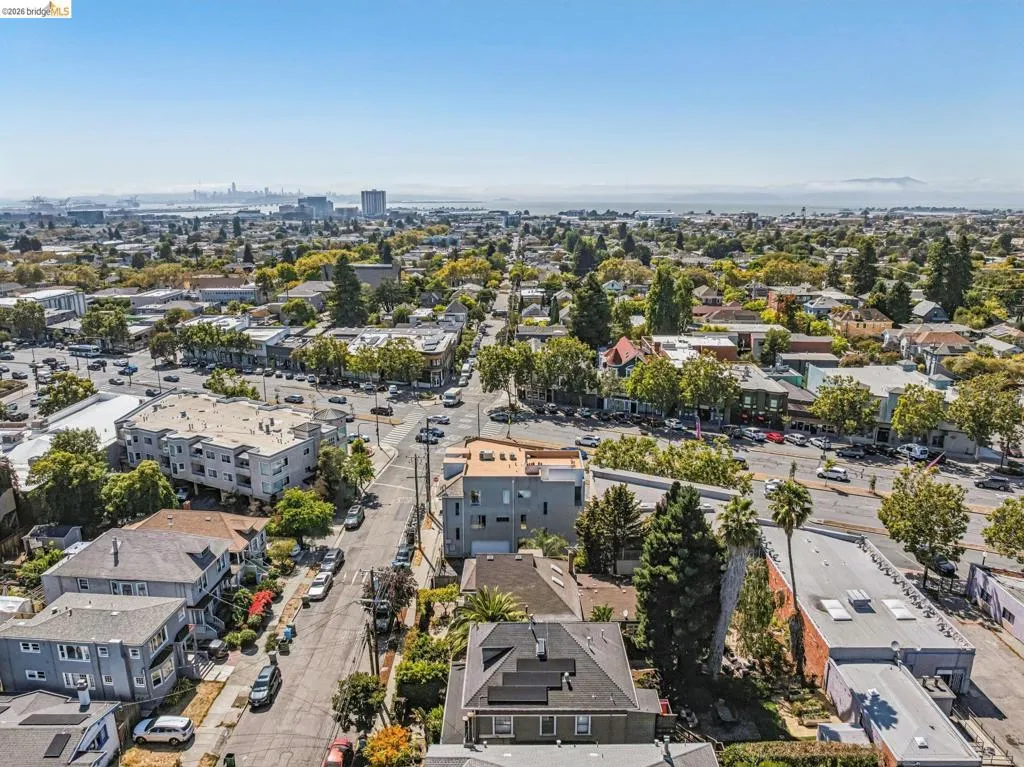 Aerial perspective of a mixed-use neighborhood featuring contemporary residential architecture, mature tree-lined streets, and established commercial corridors