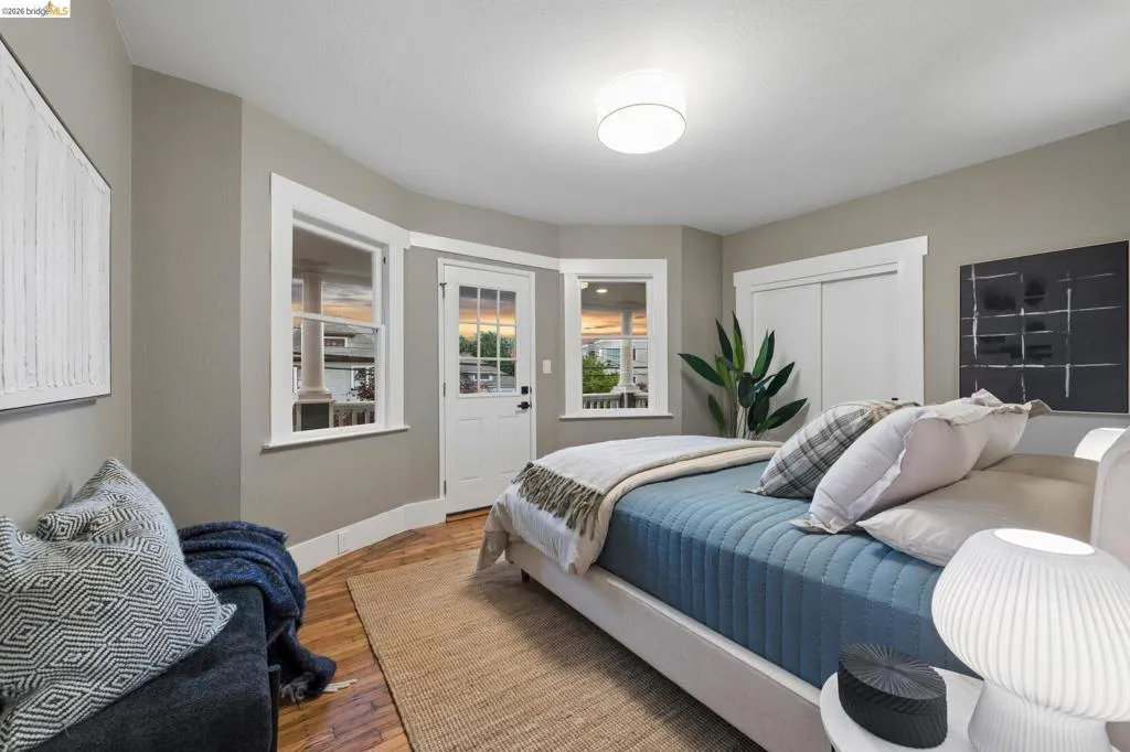 Hardwood flooring, curved wall detail, recessed lighting, white window trim, and white paneled door