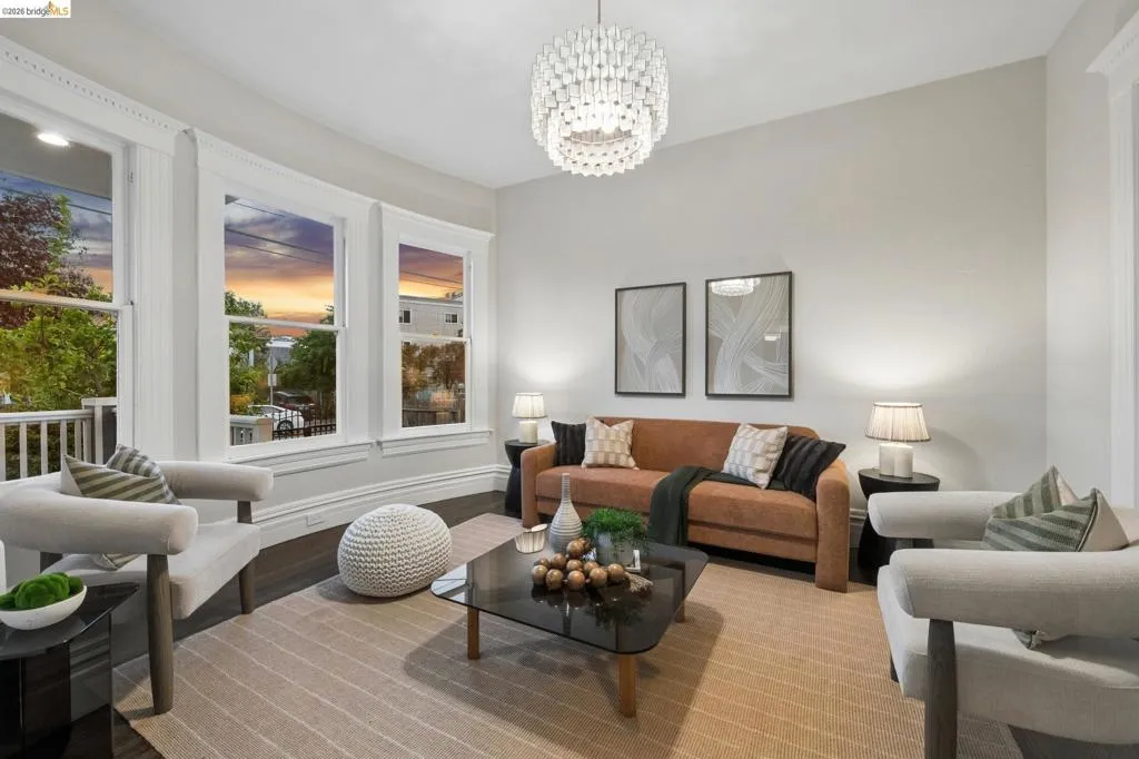 Hardwood flooring, high ceilings, decorative crown molding, bay windows, and a contemporary chandelier