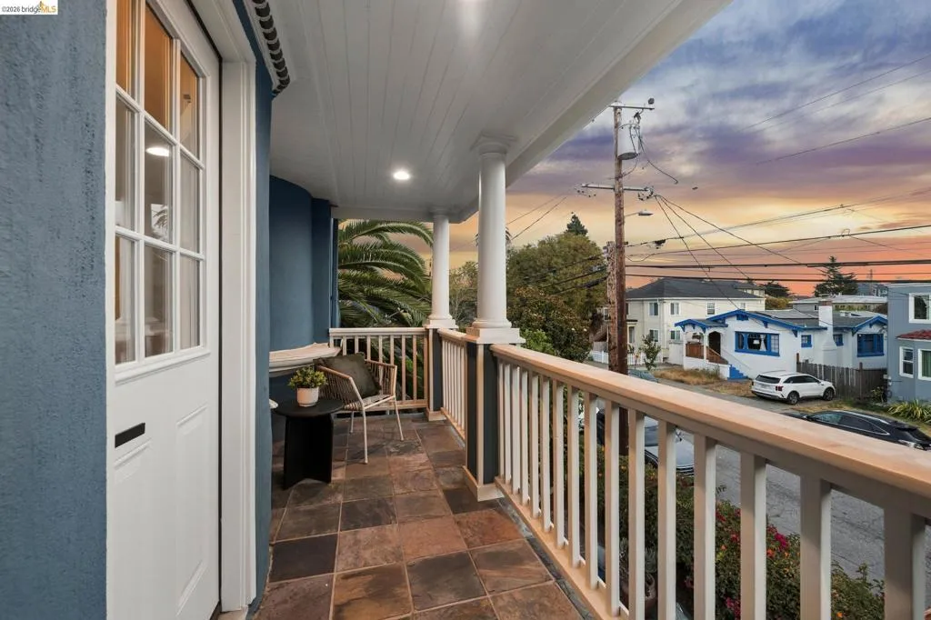 Covered balcony featuring tile flooring, white balustrade, and recessed lighting