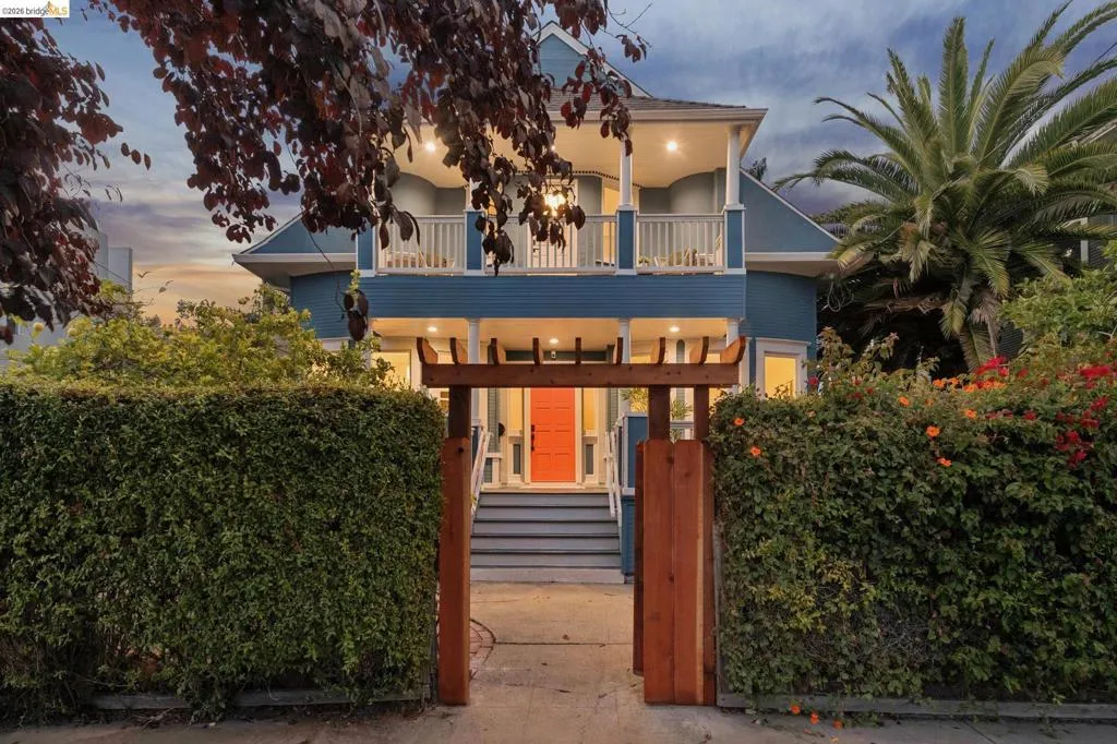 Blue exterior with white trim, featuring a balcony with white railings