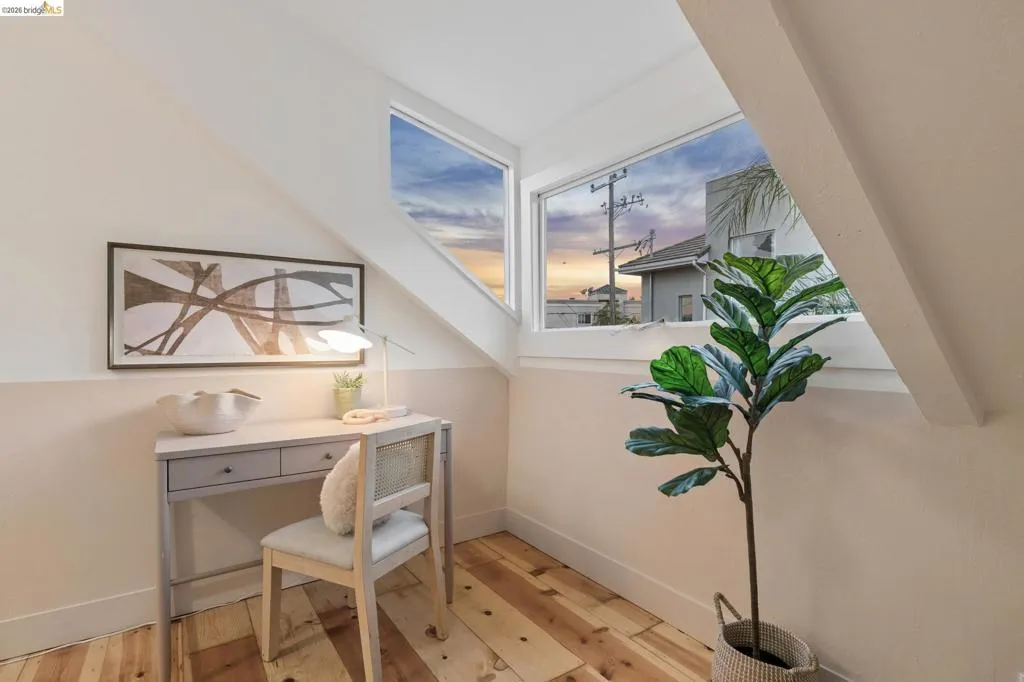 Angled white walls, wood-finish flooring, and a two-tone wall finish