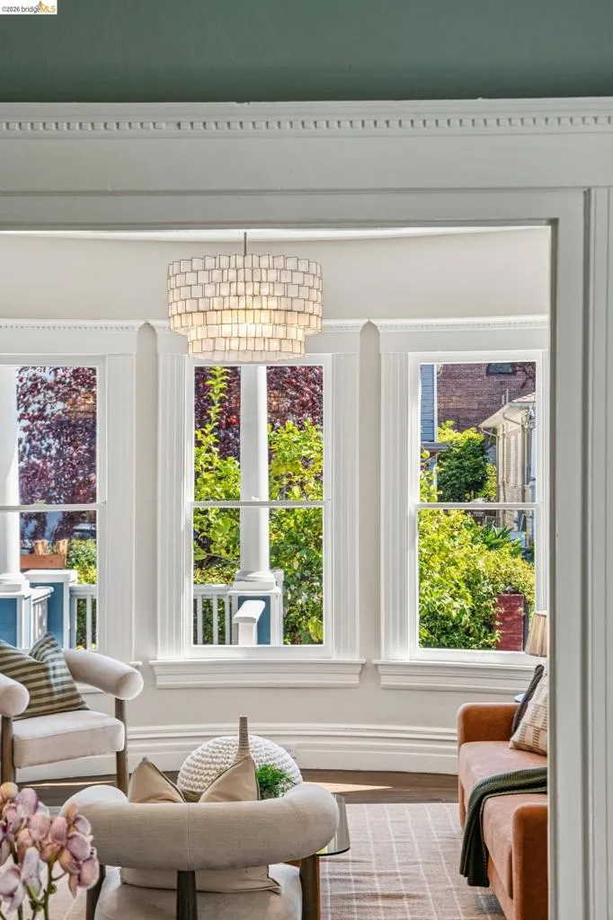 Decorative crown molding, white trim, multi-pane windows, and a tiered chandelier