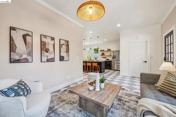 Open-concept living area with a decorative ceiling light fixture, crown molding, and recessed lighting
