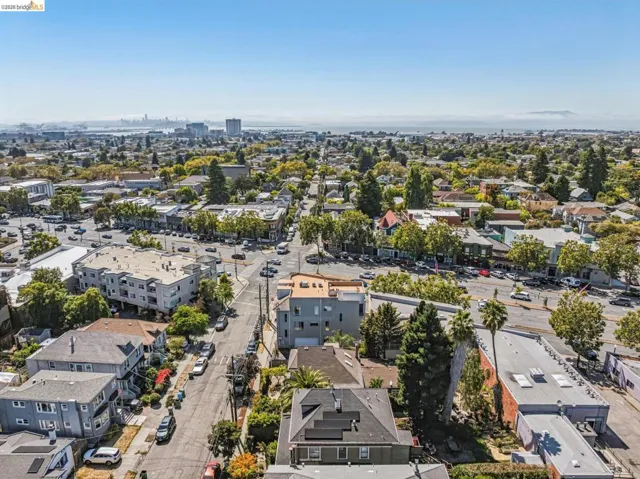 Aerial perspective of a mixed-use neighborhood featuring contemporary residential architecture, mature tree-lined streets, and established commercial corridors