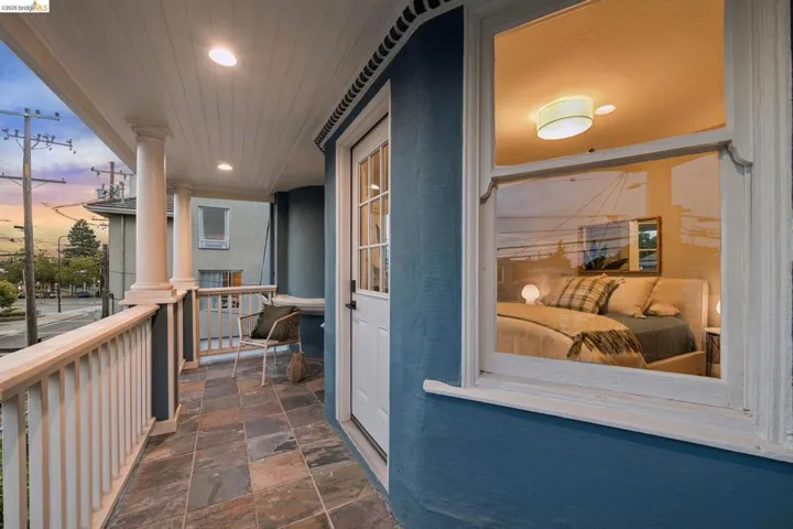 Covered front porch featuring decorative columns, a wood-slat ceiling, recessed lighting, and multi-toned stone flooring
